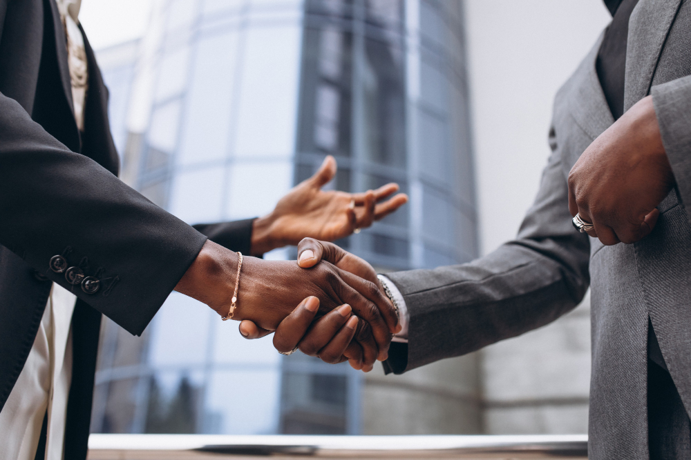 Black business professionals shaking hands in a corporate setting
